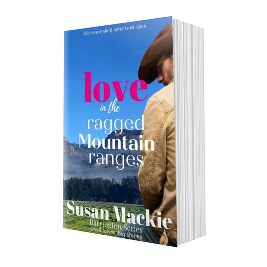 Book titled 'Love in the Ragged Mountain Ranges' by Susan Mackie with a mountain and person in cowboy hat on the cover.